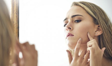 teenager examines her skin