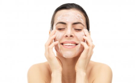 Woman cleansing her face with Gel Moussant Actif 